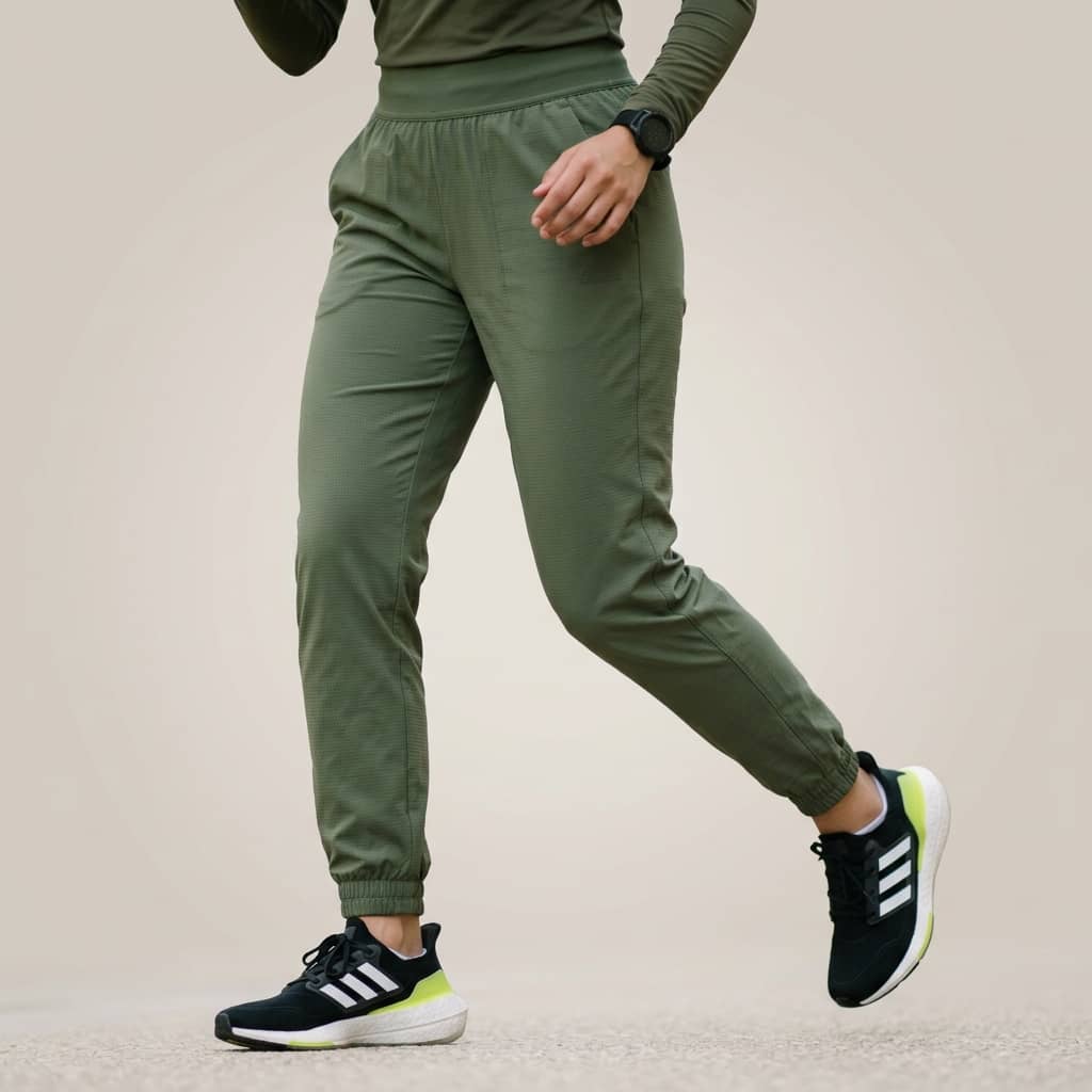 Close-up of a person wearing green pants with a neutral background
